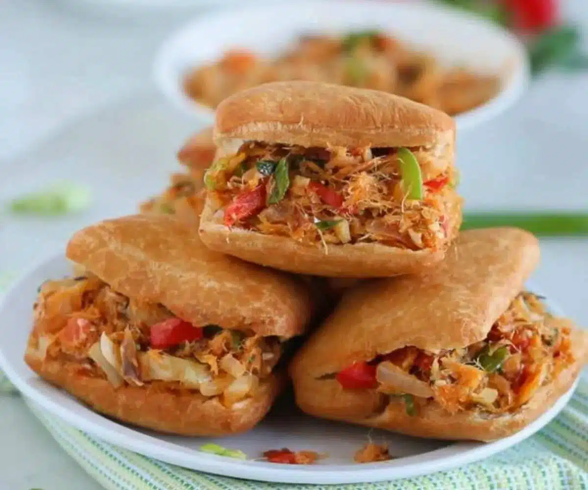 Freshly fried Guyanese bakes filled with saltfish, stacked on a plate
